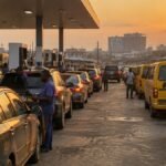 Cars and commercial buses queue at a Nigerian petrol filling station at dusk as pump prices rise in September 2026